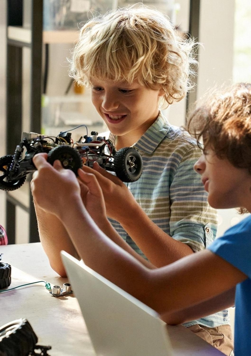 Two boys working together on a small robotics project in a UAE classroom